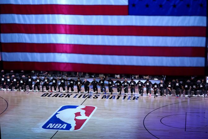 Members of the Orlando Magic and Brooklyn Nets kneel during the National Anthem before the start of an NBA game on July 31.