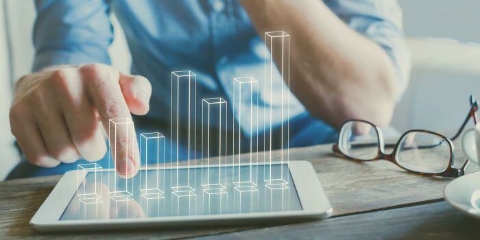 Man tapping on tablet with digitized bar graph over top representing effective erm program