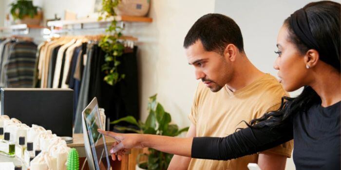 Man and woman working behind the counter in a clothing store representing retail loss prevention