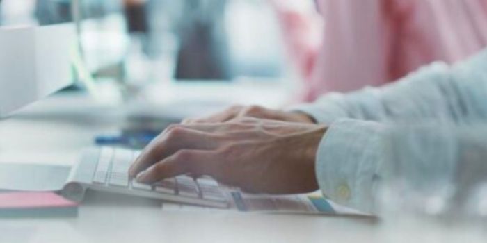 Male hands on keyboard to represent the pitfalls of a siloed risk management approach