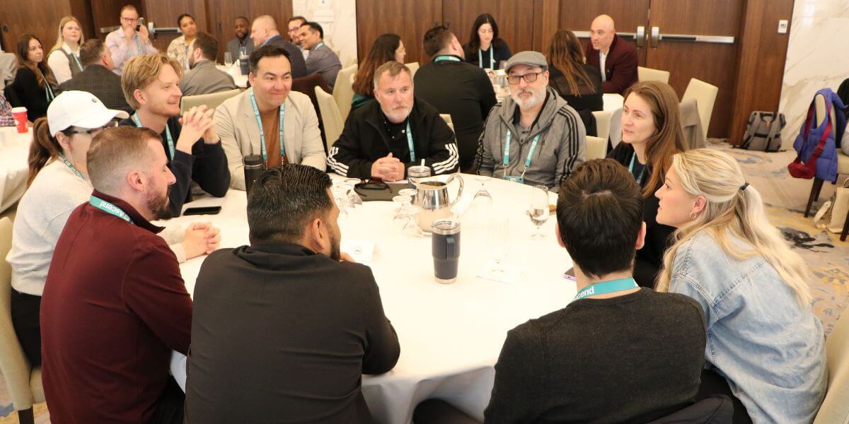 A group of attendees participate in a roundtable discussion at the ascend 2025 conference, exchanging ideas during a collaborative breakout session.