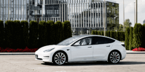 Image of white tesla outside of dealership as supplementary image for manufacturing security