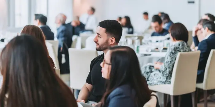 Attendees actively listening at a grc day 2024 conference session, with a focus on a male participant in the foreground.