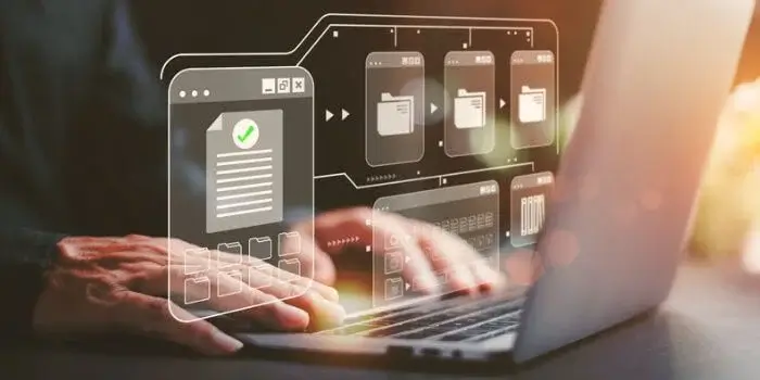 Hands typing on laptop with transparent icons above keyboard representing maintaining records to modern risk management programs